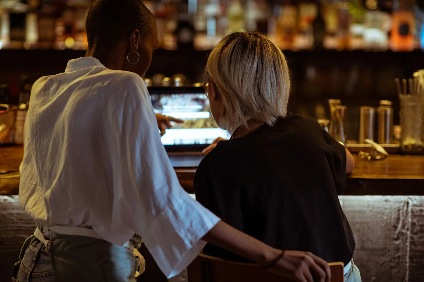 Two hospitality workers planning together at the bar